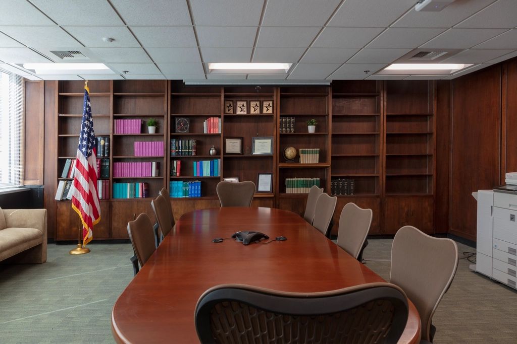A meeting room with a long table and chairs