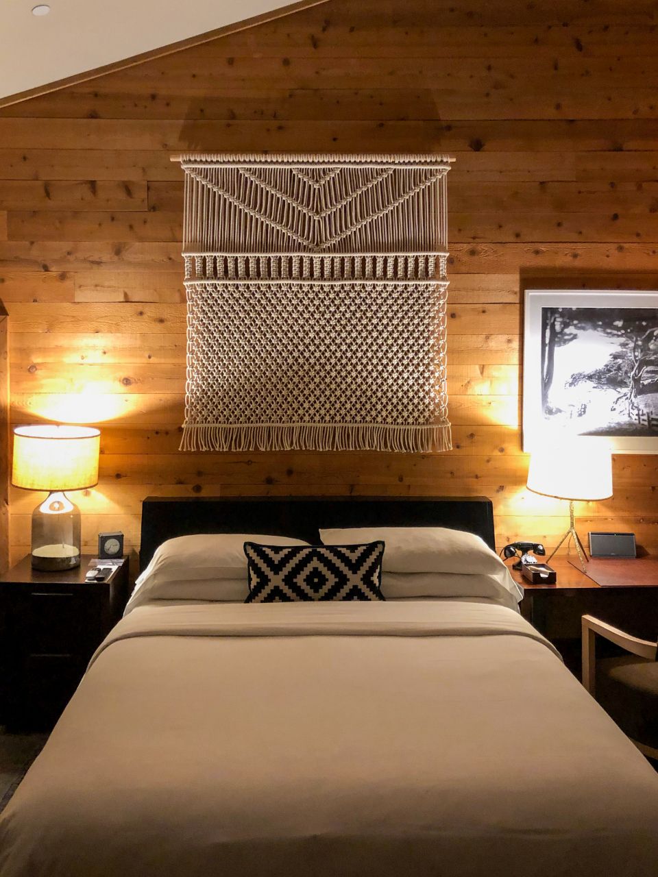 A guest room with a large bed and soft lighting