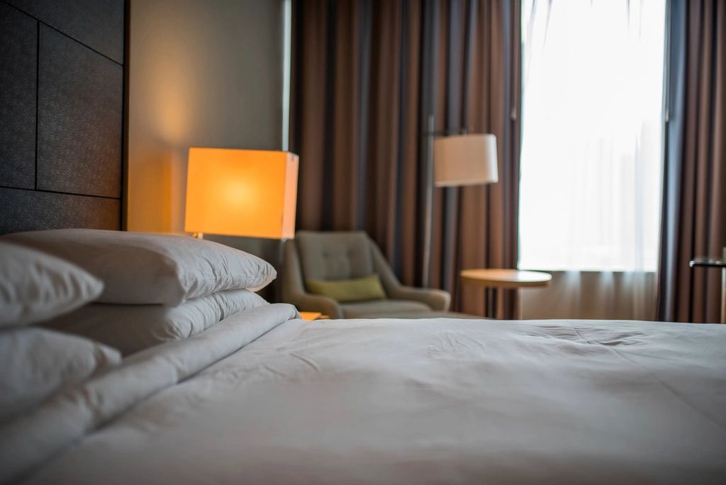 A guest room with a large bed and soft lighting